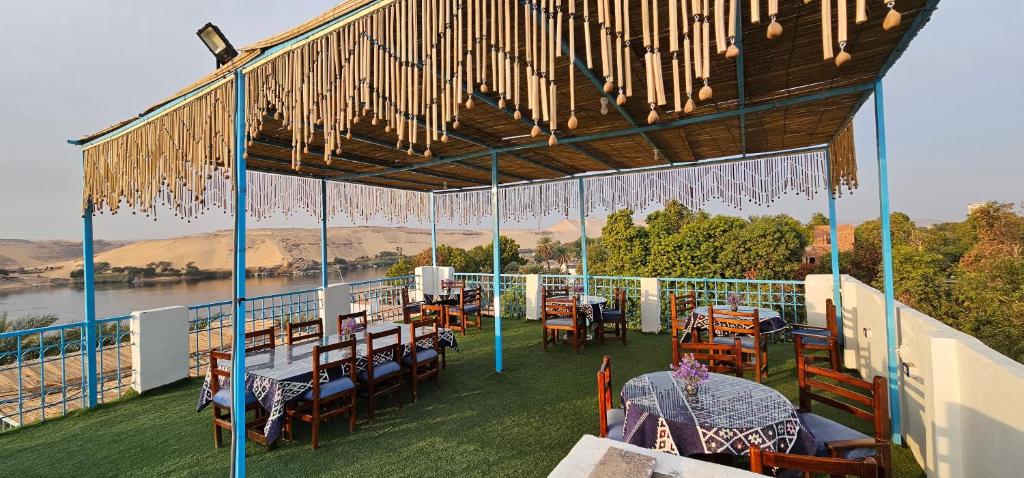 a restaurant with tables and chairs on a balcony at Basmatic Nubian Guest House in Aswan