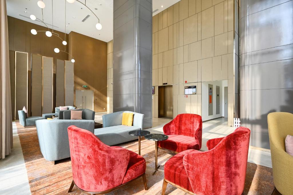a lobby with red chairs and a couch at Royal State - The Ascentia Phu My Hung in Ho Chi Minh City