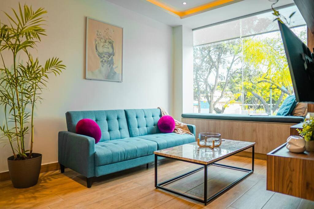 un soggiorno con divano blu e tavolo di Luxury Apartment Toscana style, brand new a Guayaquil