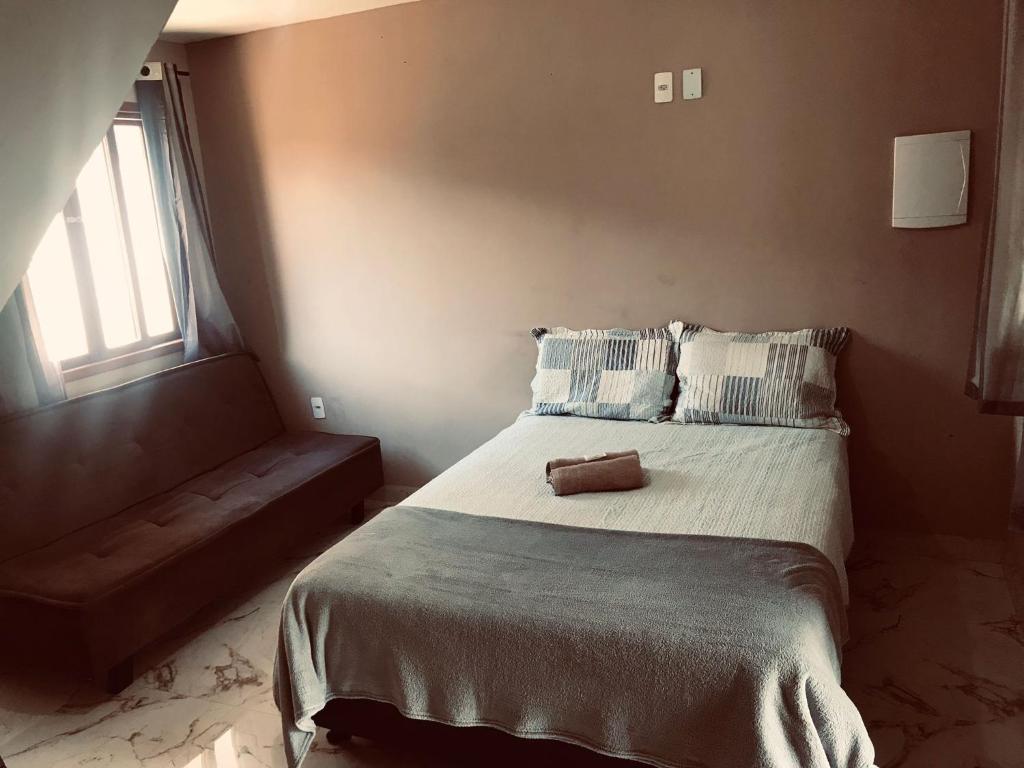 a bedroom with a large bed with blue and white pillows at Serra Mar à beira rio , rafting, suites, lofts, e Casas in Casimiro de Abreu