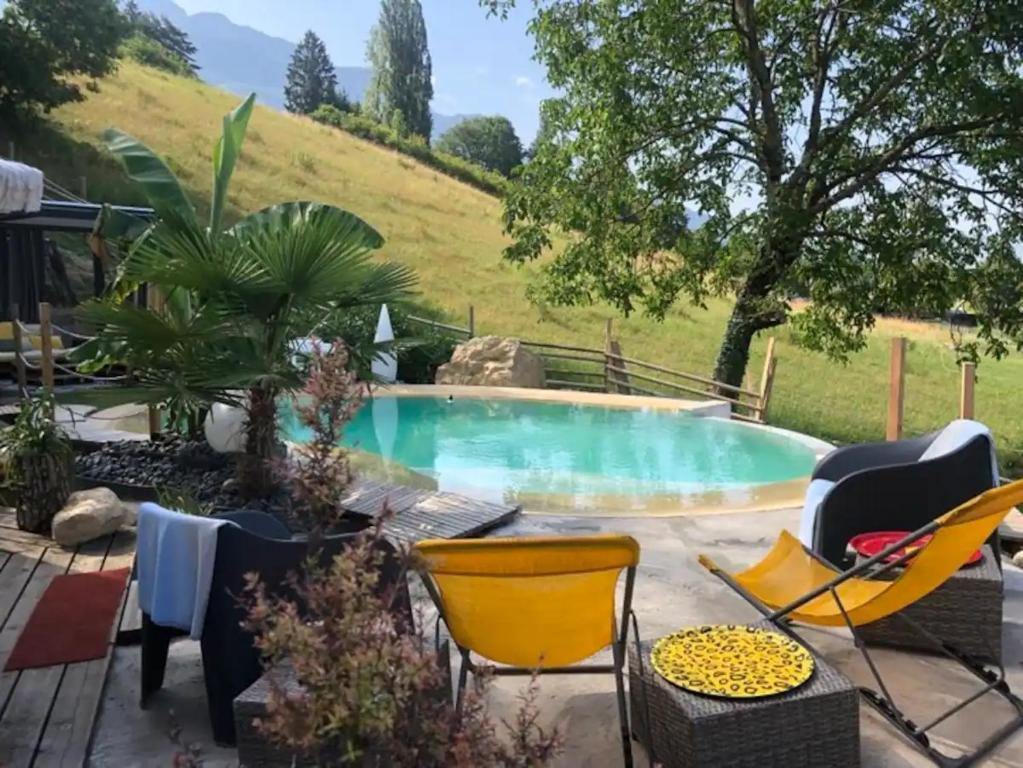 un patio con sillas y una piscina en La Marc'quize, en Mouxy