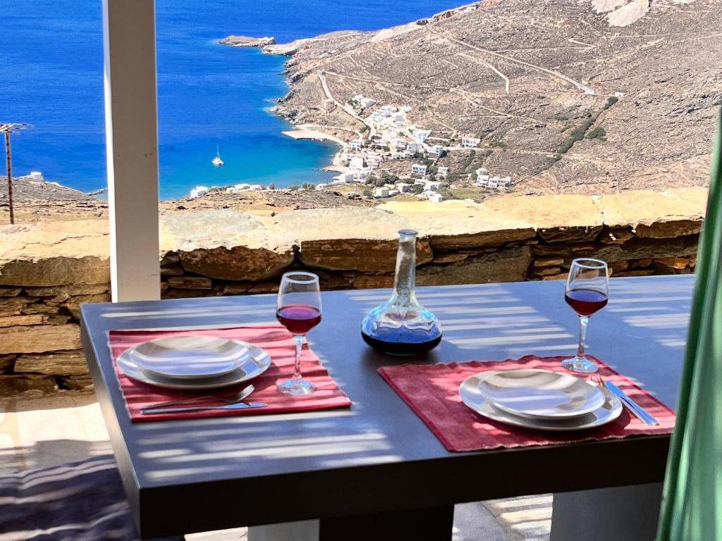 a table with two glasses of wine and a view of the ocean at Sunflower Tinos House in Istérnia