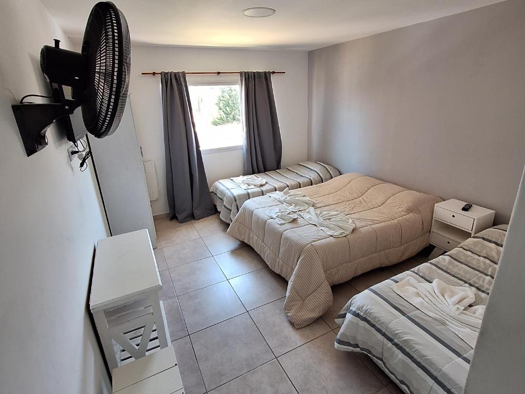 - une petite chambre avec 2 lits et une fenêtre dans l'établissement Hotel Los Angeles, à Santa Teresita