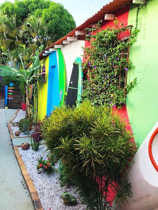 a garden with a surfboard on the side of a building at Suíte Colorida em Cabo Frio in Cabo Frio