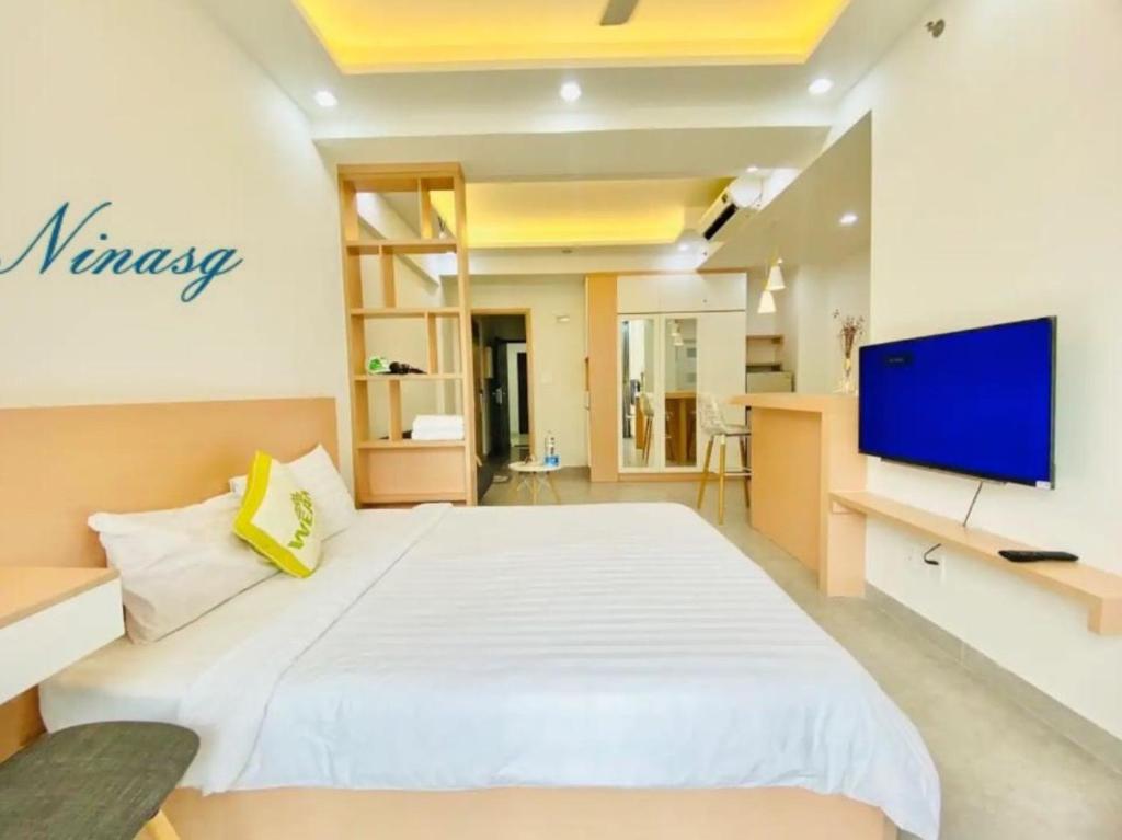 a bedroom with a large white bed and a flat screen tv at Scenic Valley With Free BreakFast, Free Massage, More Discount Supermarket in Ho Chi Minh City