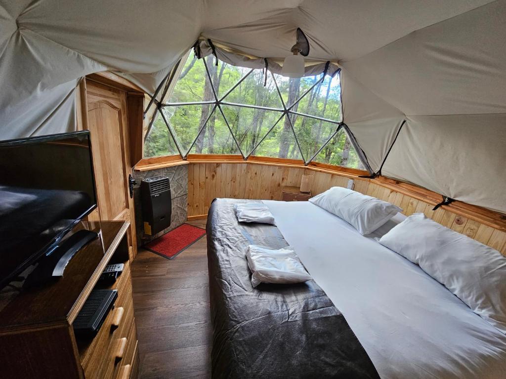 a bedroom with a large bed in a tent at Vortice Chile Eco-Lodge in Manzanar