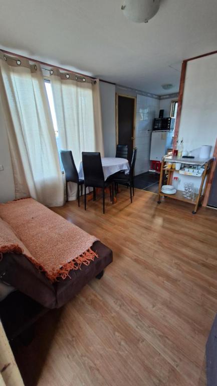 sala de estar con mesa y sillas y comedor en Cabaña Recreo frente al mar, en Viña del Mar