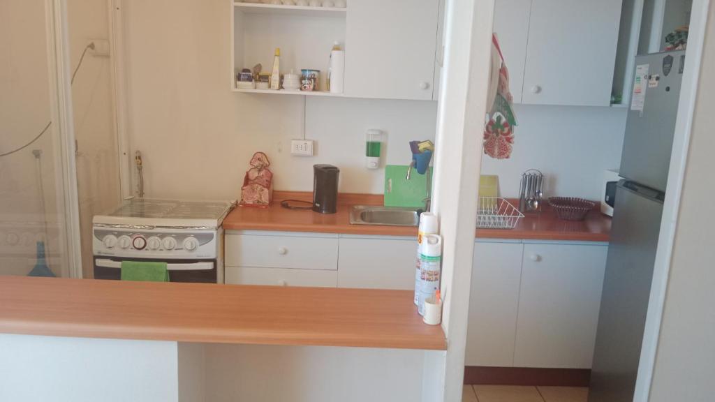 a kitchen with white cabinets and a stainless steel refrigerator at don federico tome in Tomé