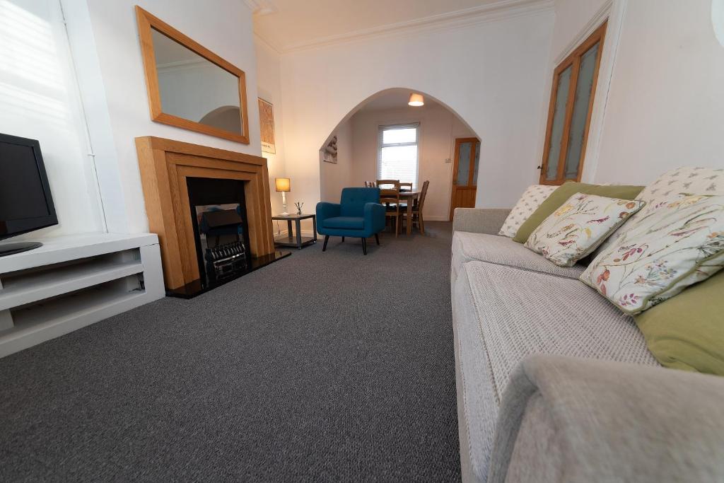 a living room with a couch and a television at Hampton House in Stockton-on-Tees