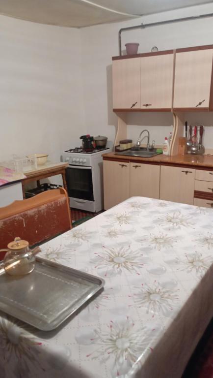 uma cozinha com uma mesa com um prato em Жилой дом em Aralʼsk