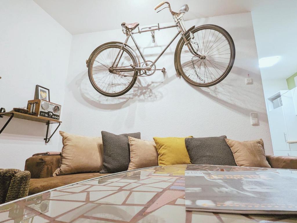 a bike hanging on a wall above a couch at Zentrale - Ferienwohnung am Thomaskirchhof in Leipzig