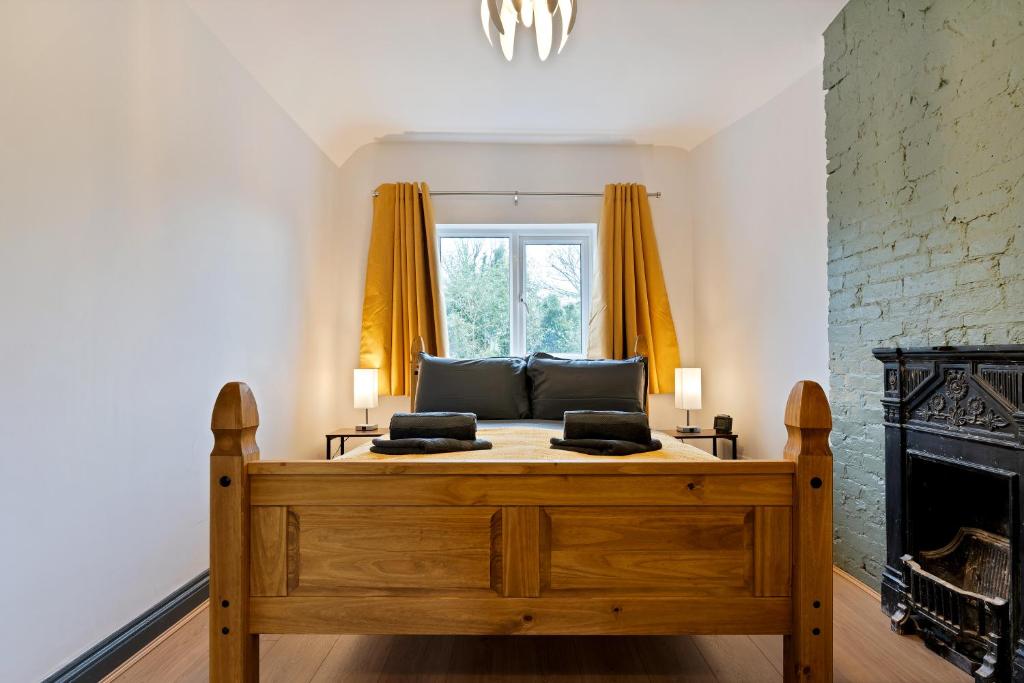 a living room with a bed and a fireplace at Sally’s Cottage - Uttoxeter: Close to Alton Towers in Uttoxeter