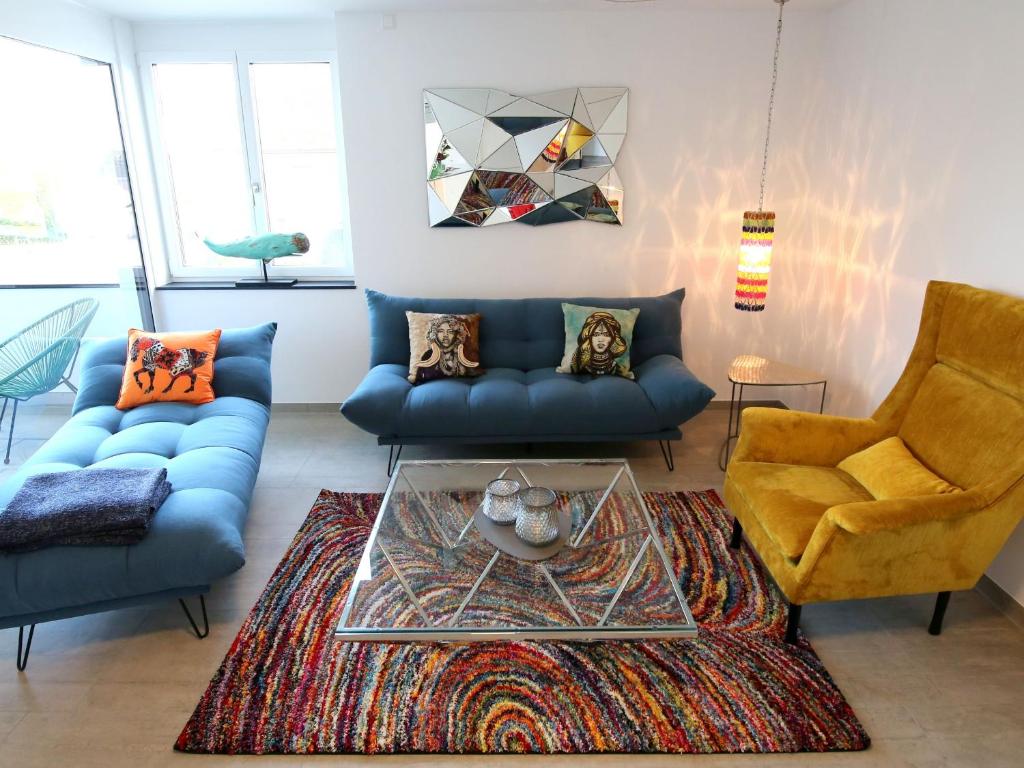 ein Wohnzimmer mit zwei blauen Sofas und einem Glastisch in der Unterkunft Purer Genuss - 110qm in Owingen