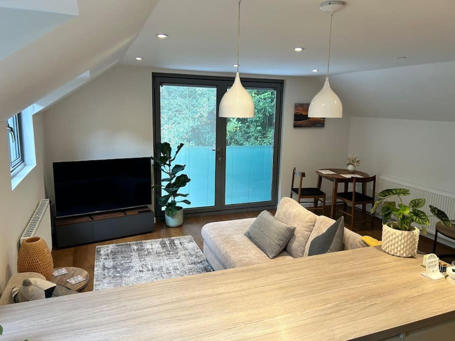 a living room with a couch and a flat screen tv at Flat in Budleigh Salterton in Budleigh Salterton