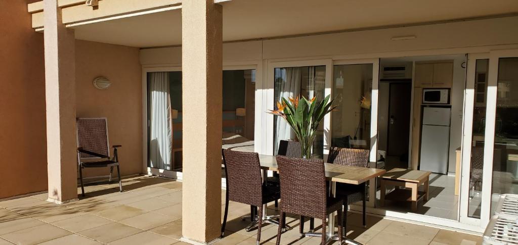 d'une table avec des chaises et un vase de fleurs sur le balcon. dans l'établissement CAP HERMES 2-3 pieces avec grande terrasse et apercu mer, à Fréjus