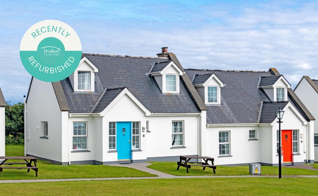 a white house with a blue and red door at Dingle Holiday Homes in Dingle