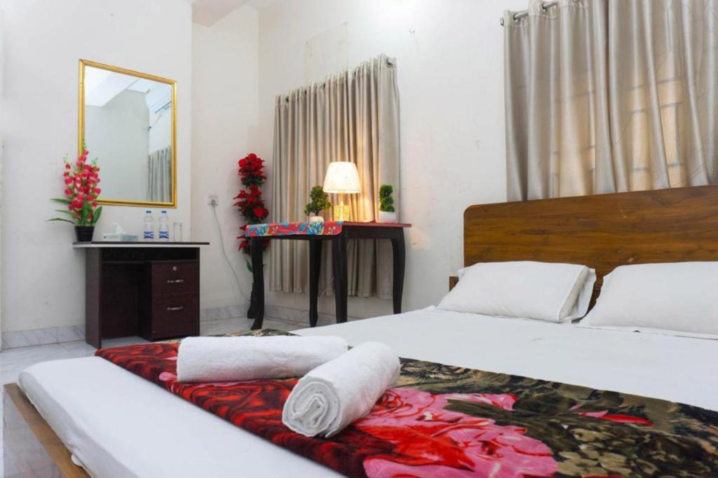 a bedroom with two beds and a mirror at Hotel White House International (Near Dhaka Medical) in Dhaka