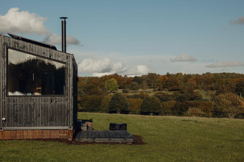 a large metal building in a field with a view at Re Cabins - Reconnect Cabin - St Albans 