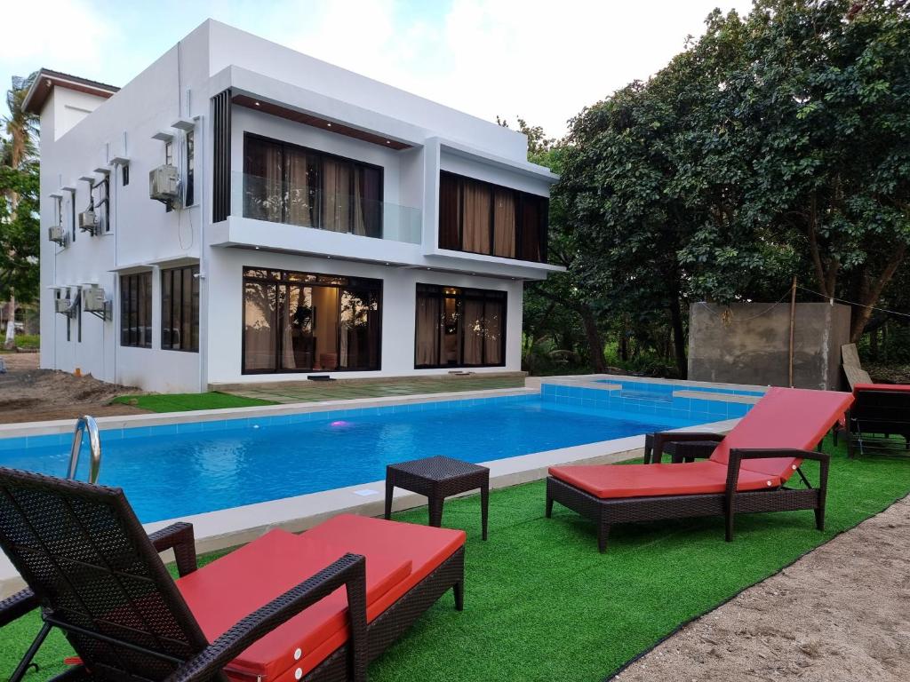 una casa con piscina al lado de un edificio en Saffire Beach Resort and Glamping en Pagudpud