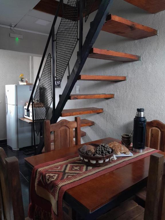 - une table à manger avec une table en bois et un escalier dans l'établissement Carileufu, à Comandante Luis Piedrabuena