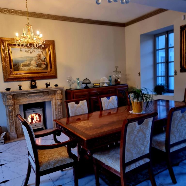 a dining room with a table and a fireplace at Chateau Roquehort in Monein