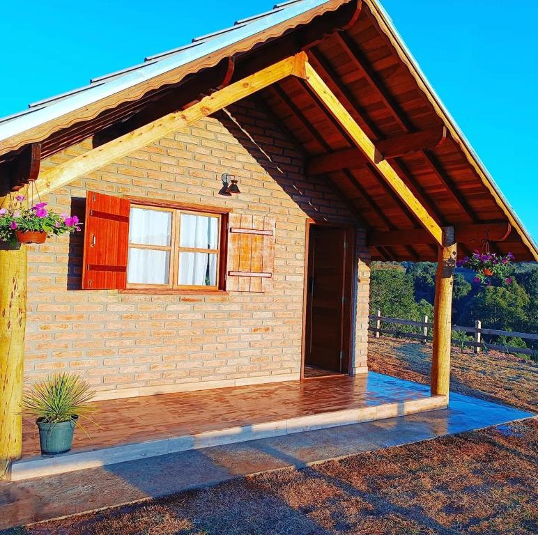 uma pequena casa de tijolos com um grande pátio em Pousada rota nas montanhas em Camanducaia