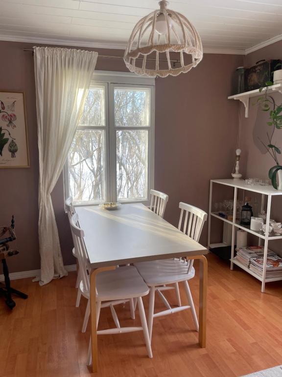une salle à manger avec une table et des chaises blanches dans l'établissement Small house central Parainen by Archipelago Trail, à Pargas