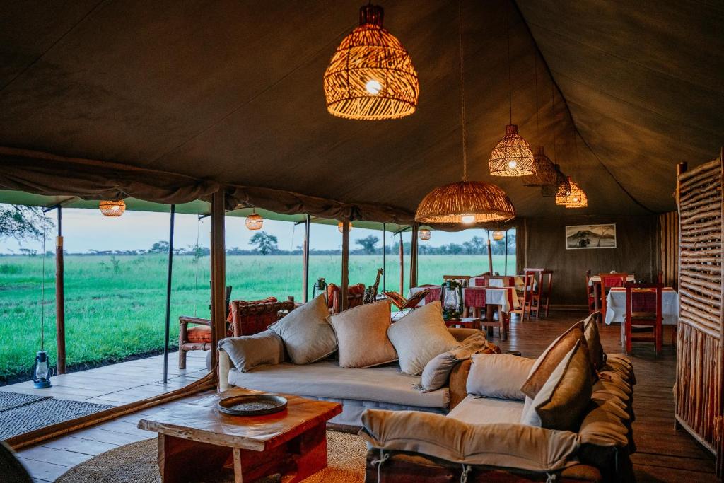 a living room in a safari tent with a couch at Zawadi Camp in Serengeti