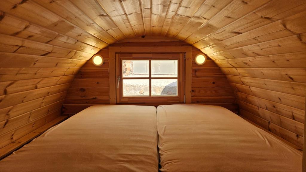 een bed in een kleine kamer met een raam bij Tiny House mit Wohnfass in Diez