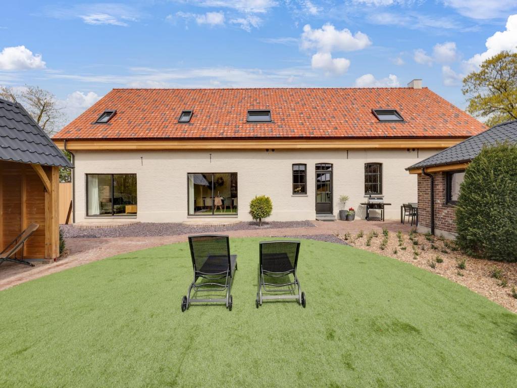 two chairs sitting on a lawn in front of a house at Vakantiehuis Bonne Home in Bree