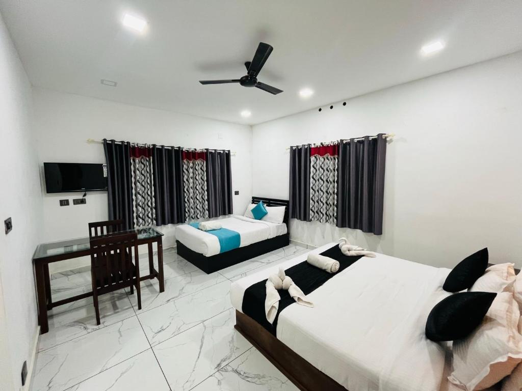 een slaapkamer met 2 bedden en een televisie. bij Mount court munnar in Munnar