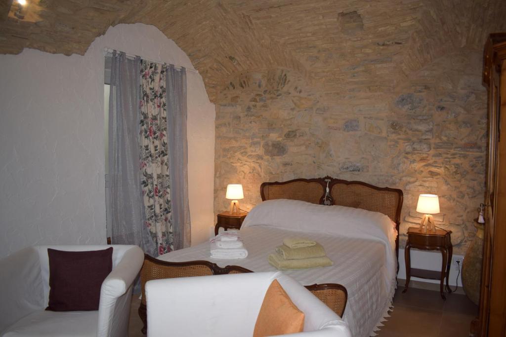 een slaapkamer met een bed, een bank en een stoel bij Il Giardino di Gio' in Imperia