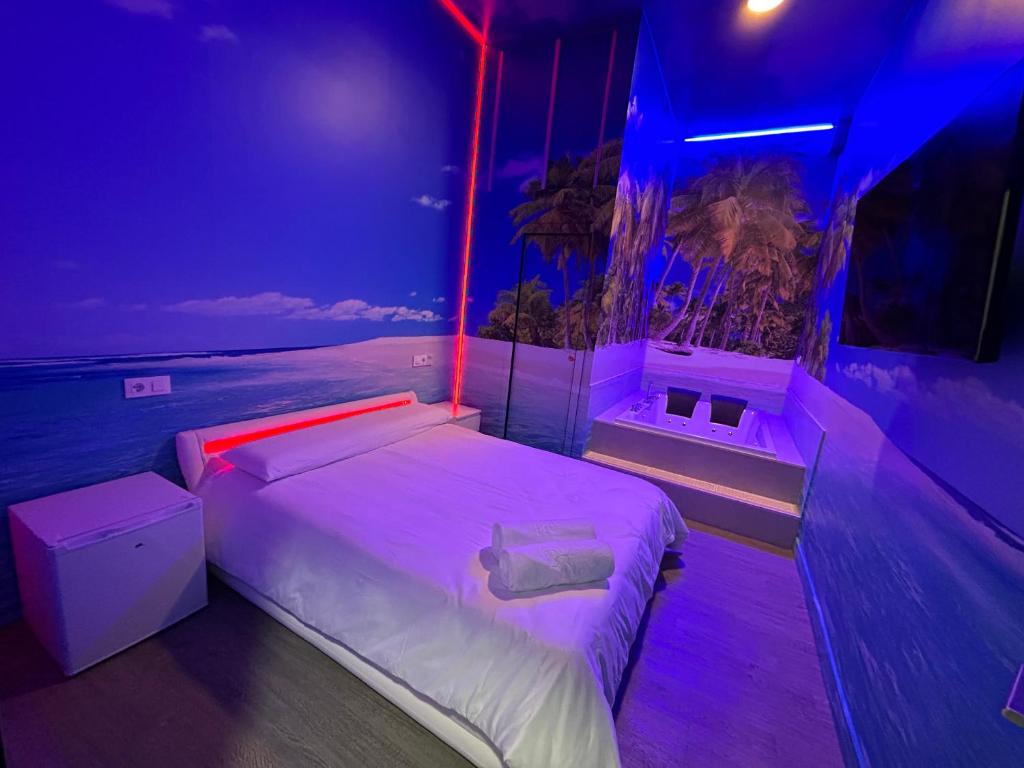 a bedroom with a bed with purple and blue lights at Habitacion con jacuzzi y baño privado in Madrid