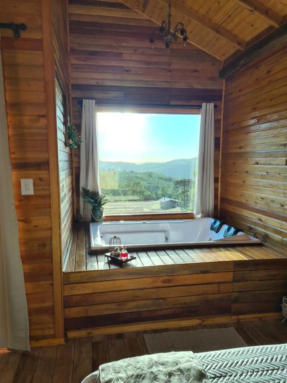 een bad in een kamer met een raam bij Alto da colina Caraá RS in Caraá