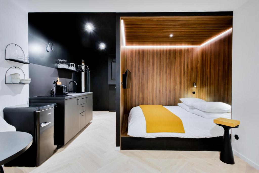 - une chambre avec un lit et un mur en bois dans l'établissement Le Bijou de Poincaré - Centre Gare, à Nancy