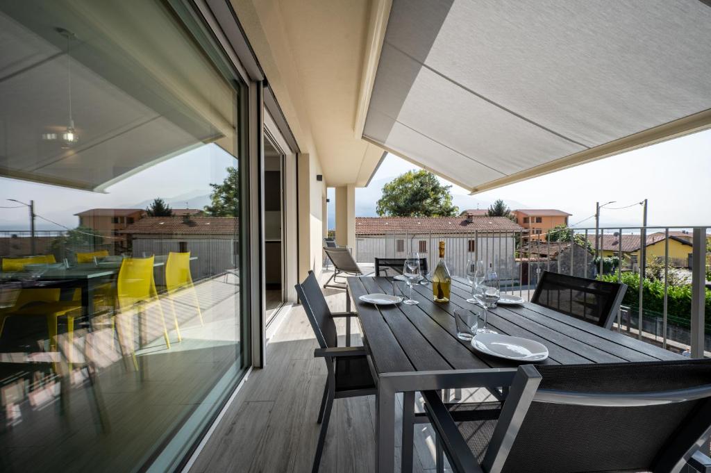 een patio met een houten tafel en stoelen bij Casa Marianna in Gravedona