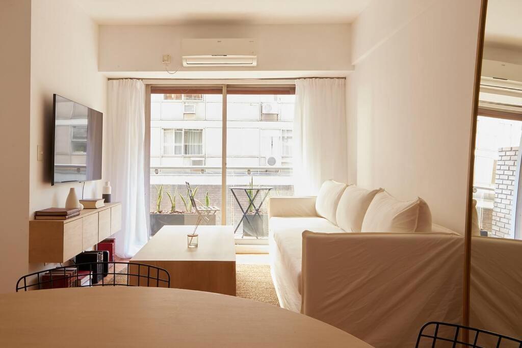 a living room with a couch and a large window at Hestia At Patio Bullrich 1bdr Apartment in Buenos Aires