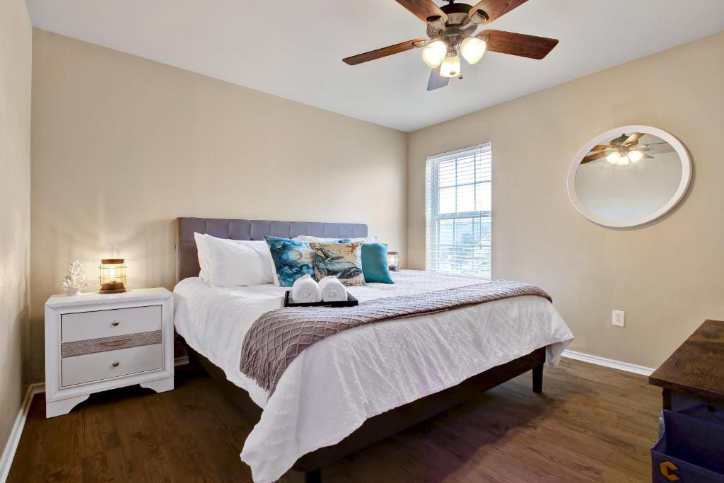 a bedroom with a bed with a ceiling fan at Aqueous - A Birdy Vacation Rental in San Antonio