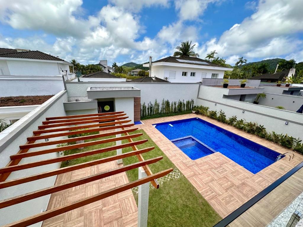 a swimming pool on the roof of a house with benches at NoMar in Guarujá