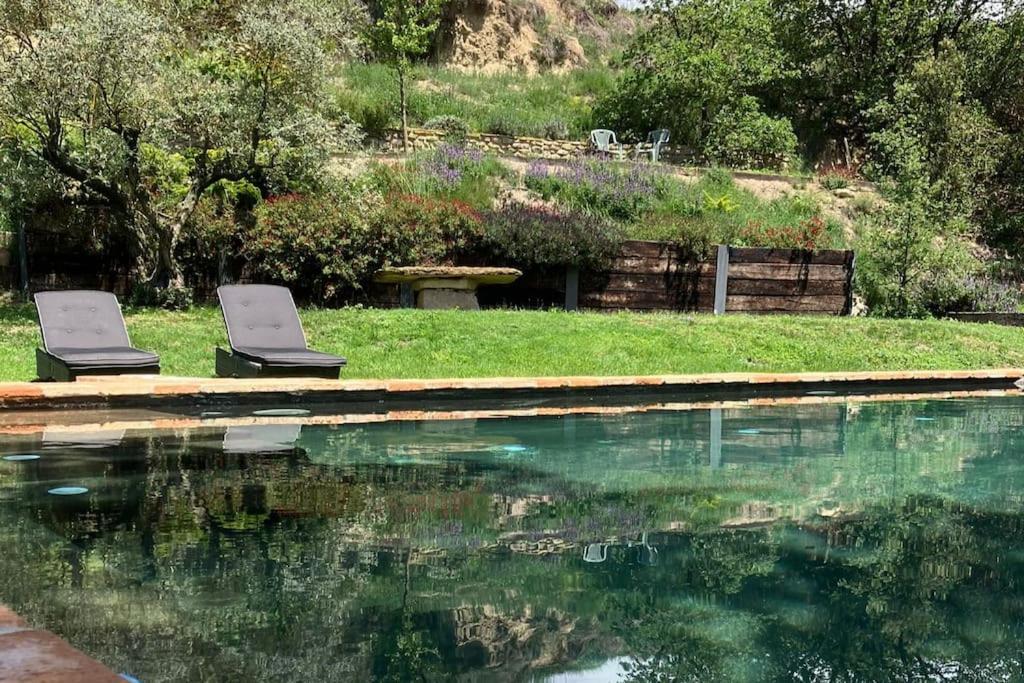 dos sillas sentadas junto a una piscina de agua en El Vespelló, en El Gurb