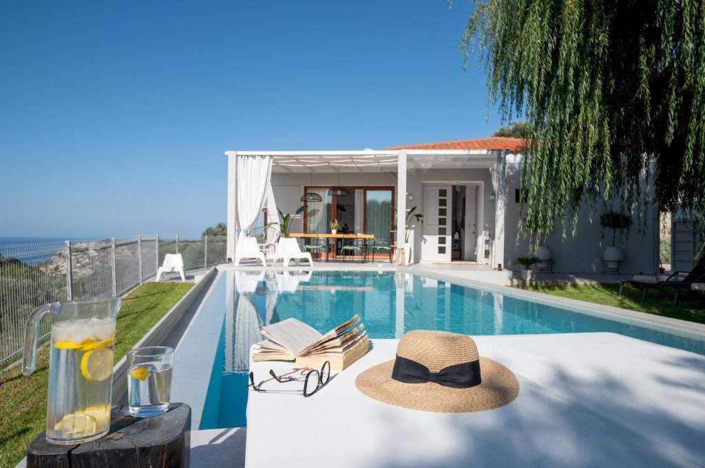 une villa avec une piscine et un chapeau sur une table dans l'établissement Canyon 1 Elegant villa, à Réthymnon