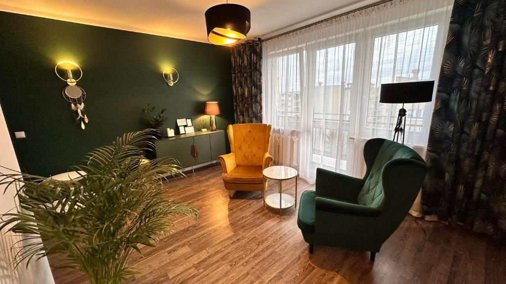 una sala de estar con 2 sillas y una planta en 3Klucze, en Tomaszów Mazowiecki