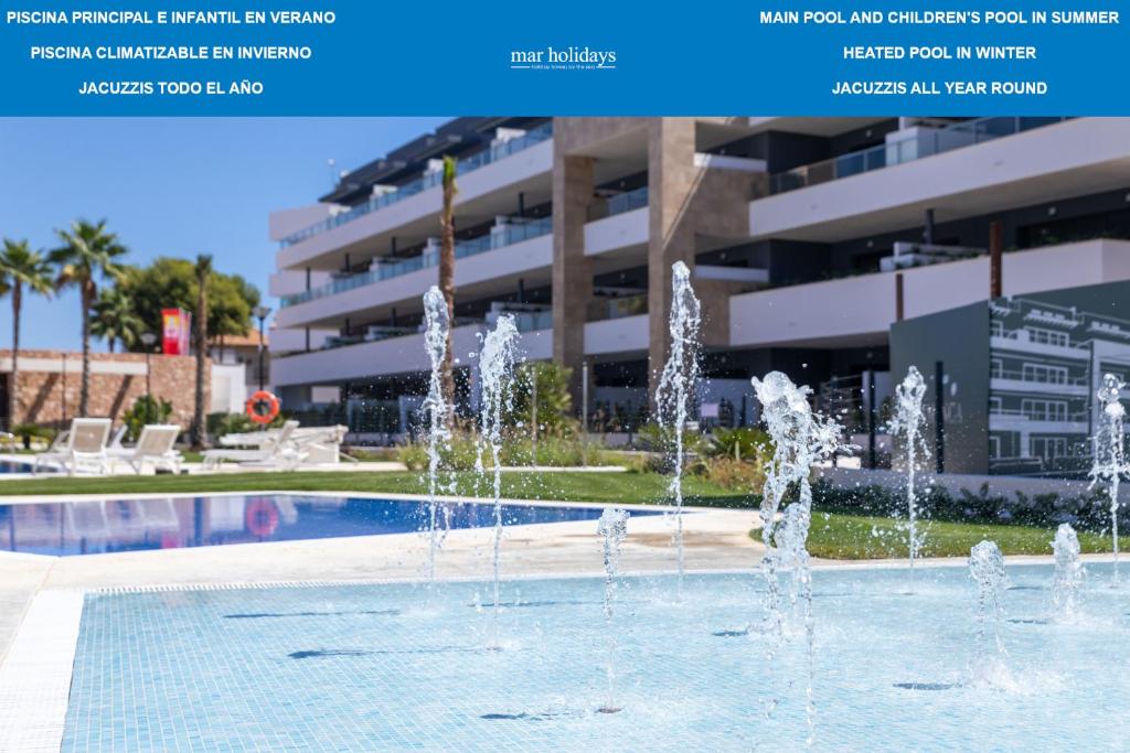 a pool with water fountains in front of a building at Flamenca Village by Mar Holidays in Orihuela