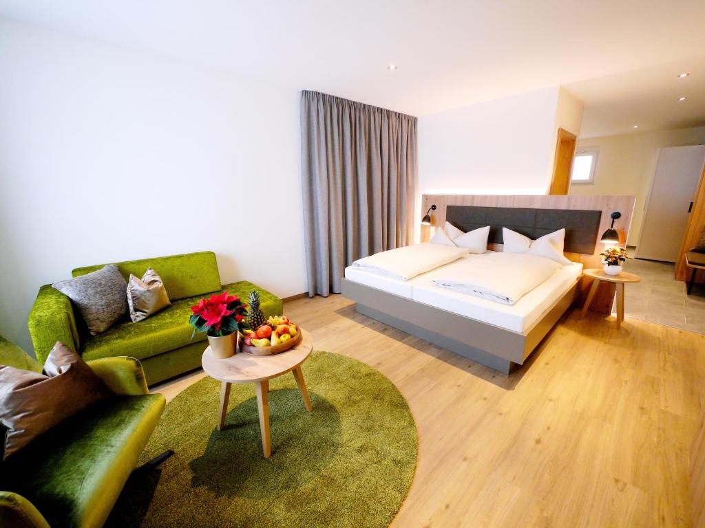 アルプシュタットにあるベルクホテル ツォラーシュタイクホーフのベッドとソファ付きのホテルルーム