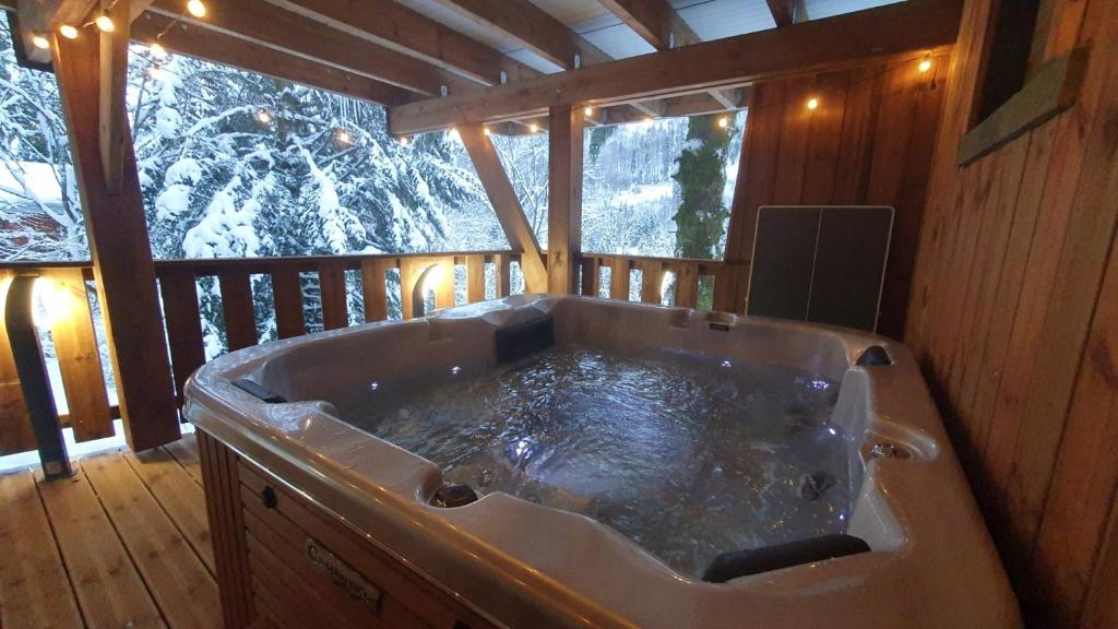 a large bath tub in a cabin with a window at Chalet Le Dahu in La Bresse