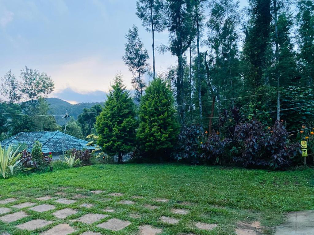a yard with trees and grass and a fence at Timber leaf stay in Avathi