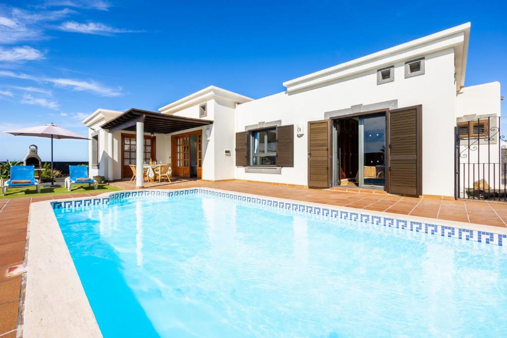 Villa con piscina frente a una casa en Villa Capricho en Playa Blanca