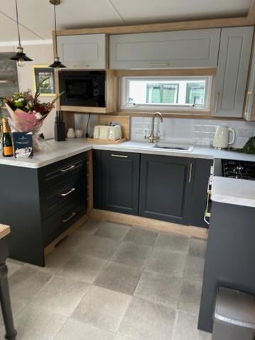 una cocina con armarios azules y fregadero en White Cross Bay Deer View, en Windermere