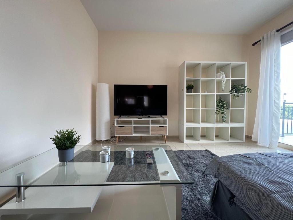 a living room with a flat screen tv and a bed at Coastal Elegance Maisonette in Limassol