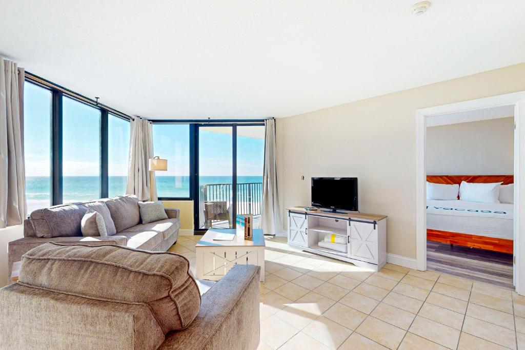 a living room with a couch and a bed at Sunbird #408E in Panama City Beach